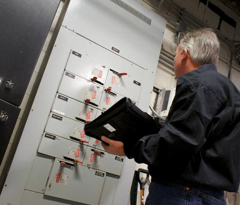 Tech Inspects Switches In Commercial Building
